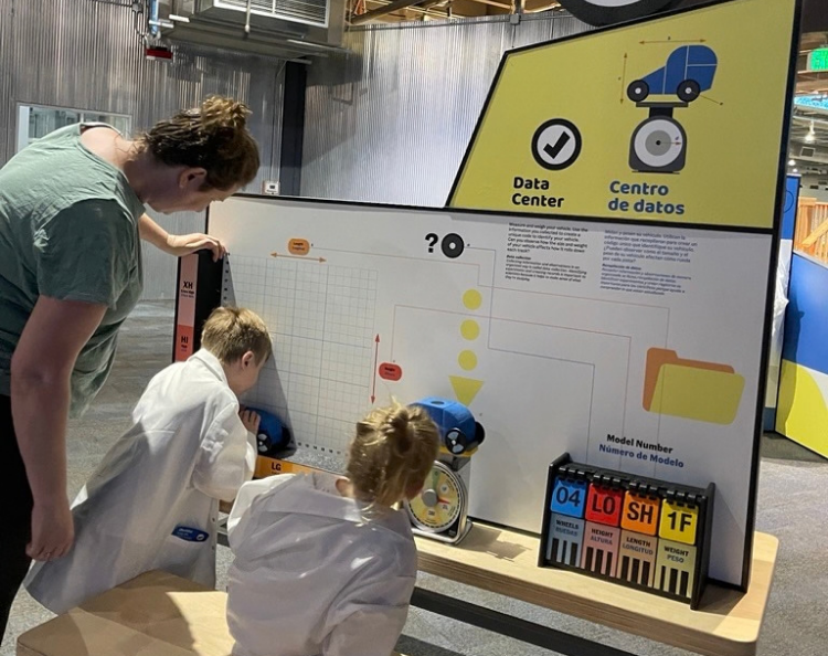 Mom and two children, one boy and one girl, play with the Mobilab exhibition at Science Museum Oklahoma.