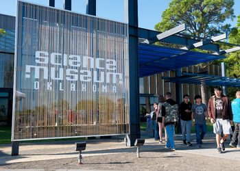 A picture of boys walking out of the front entrance of Science museum oklahoma 