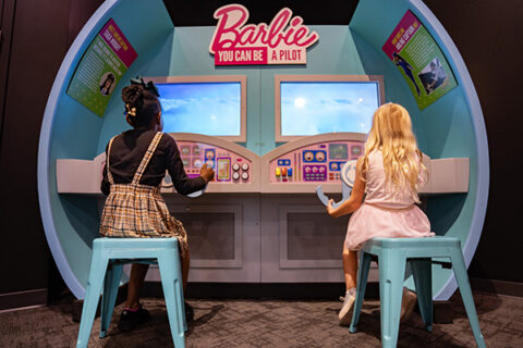 Two girls play at an exhibit in Barbie You Can Do Anything featured at Science Museum Oklahoma