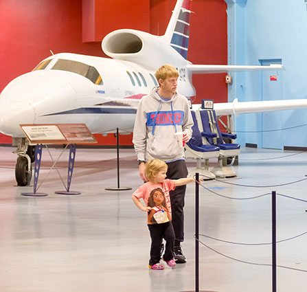 An adult and a child are visiting the Aviation exhibits at Science Museum Oklahoma.