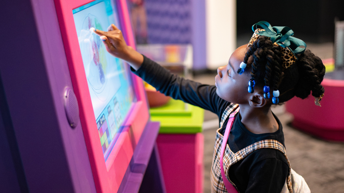 A girl plays at an exhibit called Barbie at Science museum oklahoma