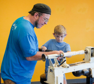 a community partners turns wood with a discoverfest guest at science museum oklahoma