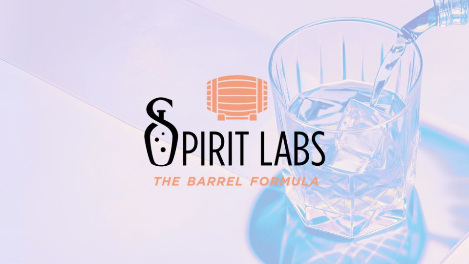 Logo for Spirit Labs with a barrel icon and the subtitle "The Barrel Formula" over a photo of whiskey being poured into a glass with ice.