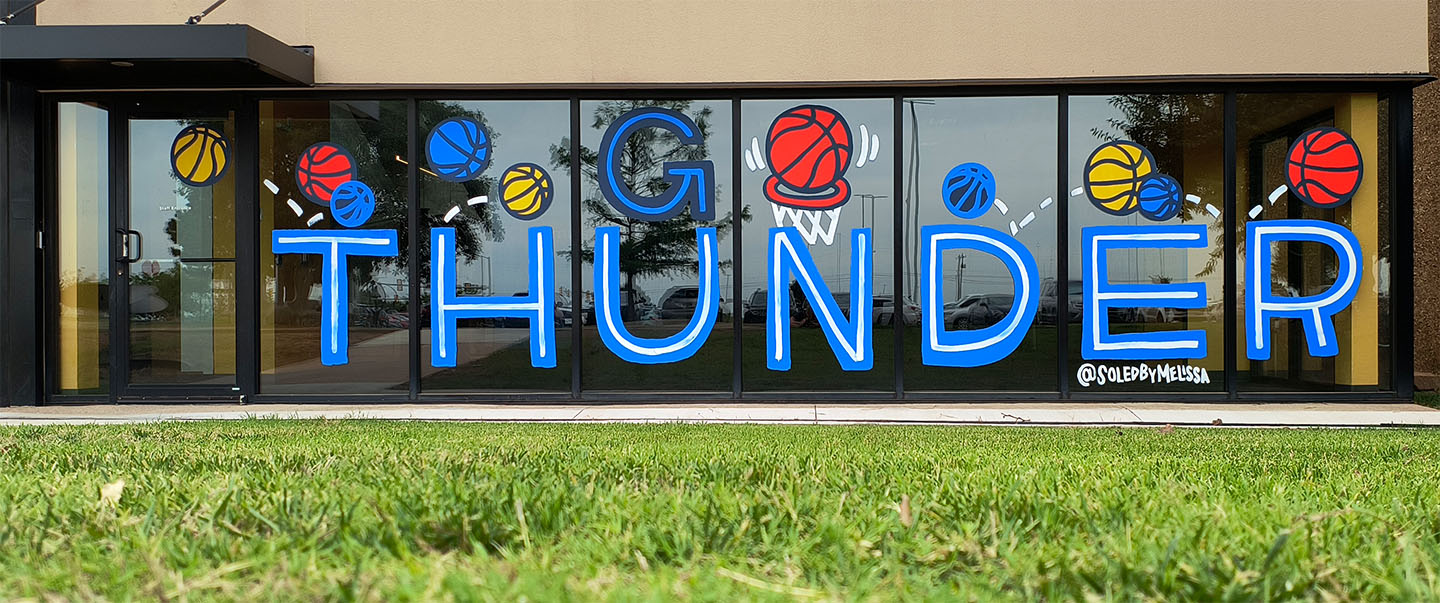 Window mural at Science Museum Oklahoma featuring “Go Thunder” in bold letters with colorful basketball illustrations in support of the Oklahoma City Thunder NBA team