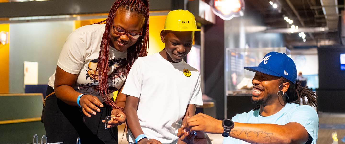 A family participates in a hands-on STEM activity at Science Museum Oklahoma, exploring circuits and experiments in an interactive exhibit space at DiscoverFest.