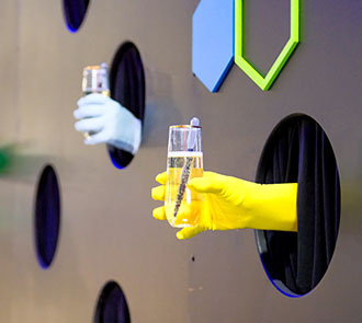 Gloved hands serve cocktails through a wall at Science Museum Oklahoma's fundraiser Elemental Ball.