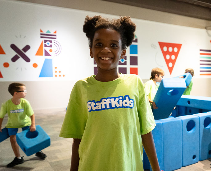 Child is on a field trip at science museum oklahoma smiling for the camera.