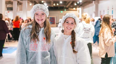Two girl students embrace at an event for females at Science Museum Oklahoma.
