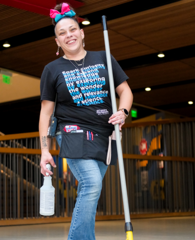 woman cleans the floor at science museum oklahoma with a smile