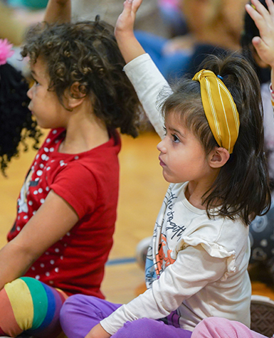 Girl raising hand at assembly on the go program