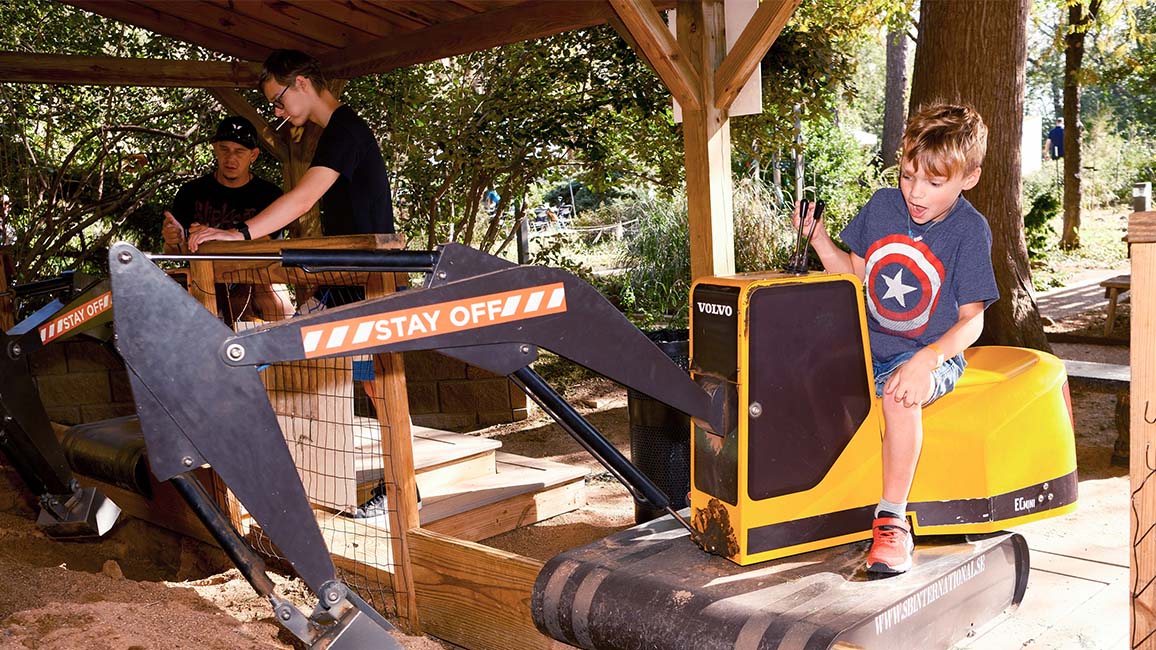 Child operates a hands-on excavator exhibit in the outdoor science park at Science Museum Oklahoma.