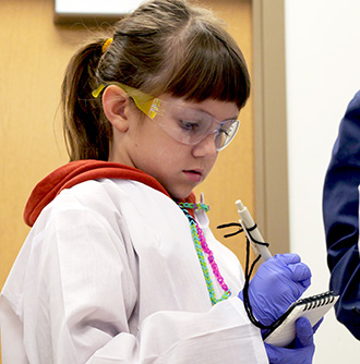 girl looks at a notepad concentrating on an homeschool day activity at science museum oklahoma