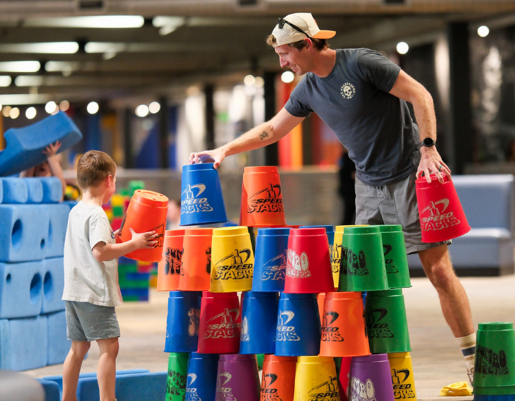 A father plays with giant cups with his son at science museum oklahoma