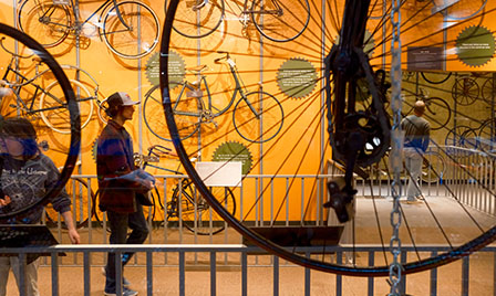 Guests explore the Cycle Dynamics exhibit at Science Museum Oklahoma, showcasing vintage bicycles and interactive mechanical science displays.