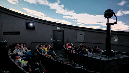 An excited audience watching the incredible visuals from the Love’s Planetarium at Science Museum Oklahoma.