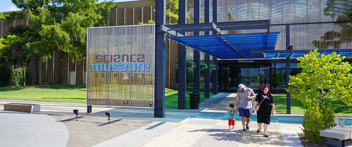 A family exits the front entrance of Science Museum Oklahoma, located in Oklahoma City’s Adventure District with free on-site parking for all guests.