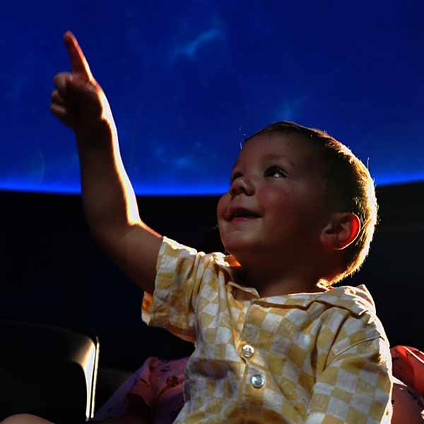 A young child points to the projection on the dome of the Love's Planetarium at Science Musuem Oklahoma.