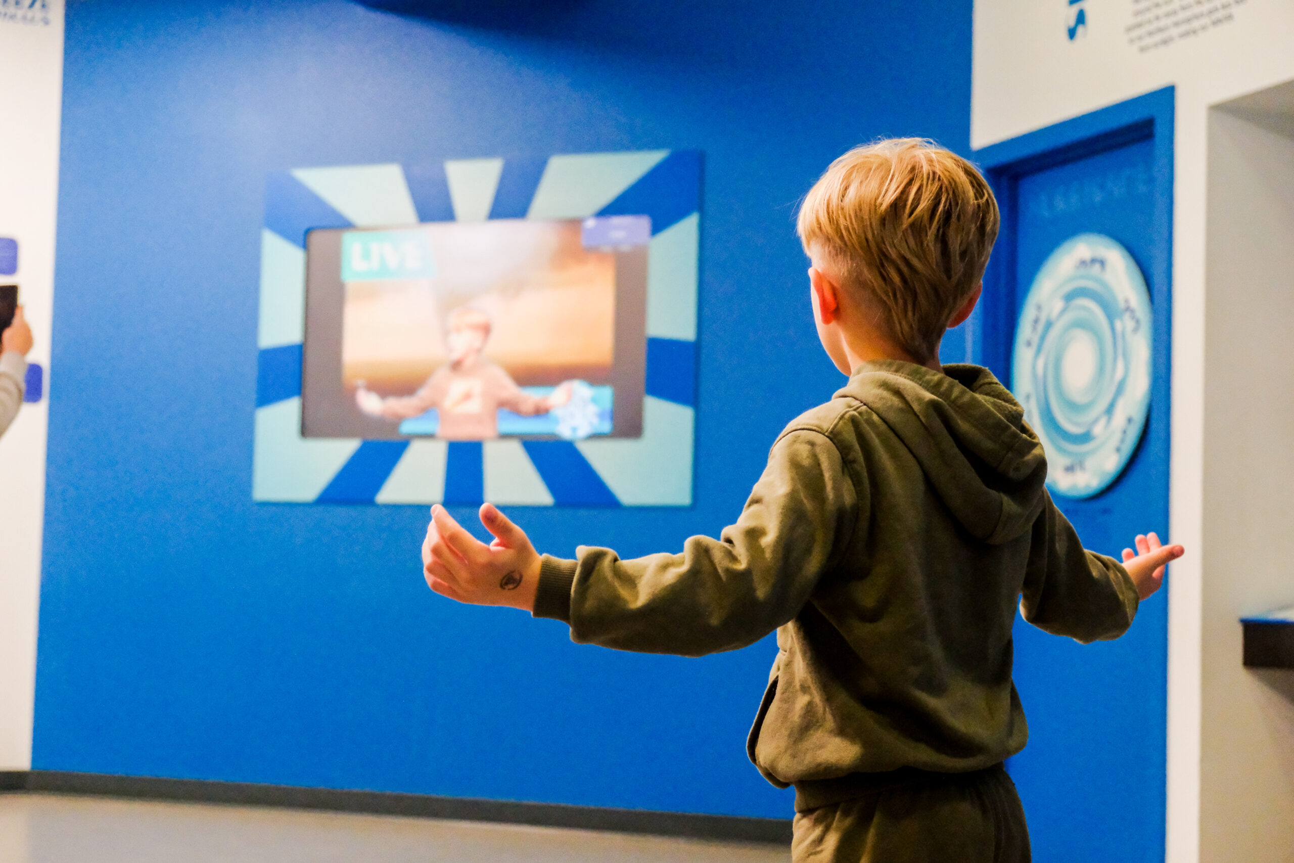 A young boy poses in the Eye on the Sky weather exhibit at Science Museum Oklahoma.