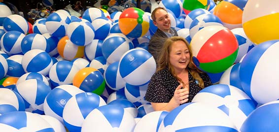 Two adults play in a ball pit at Science Museum Oklahoma's Elemental Ball fundraiser.