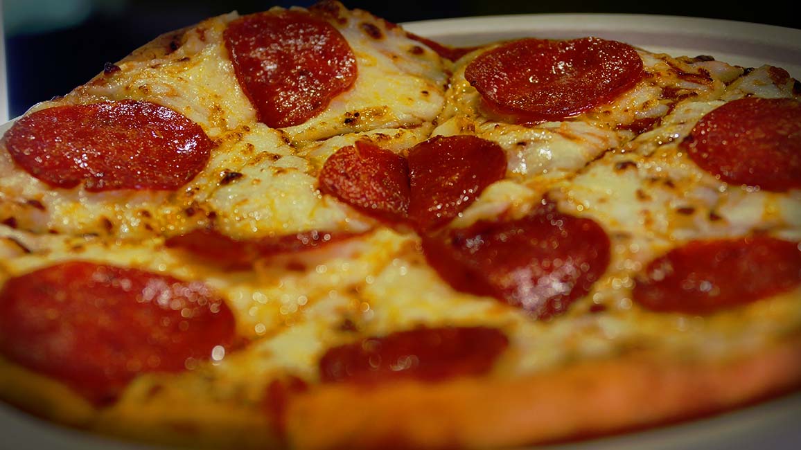 A close-up of a fresh cheesy pepperoni pizza served at Pavlov’s Café in Science Museum Oklahoma.