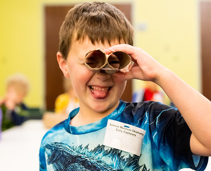 Boy plays with his cardboard creation from STEM camps at science museum oklahoma.