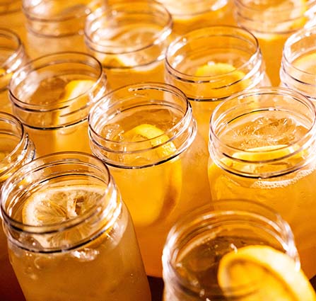 Rows of mason jars filled with iced tea and lemon slices are prepared for guests at Science Museum Oklahoma’s SMO21+ adults-only event.