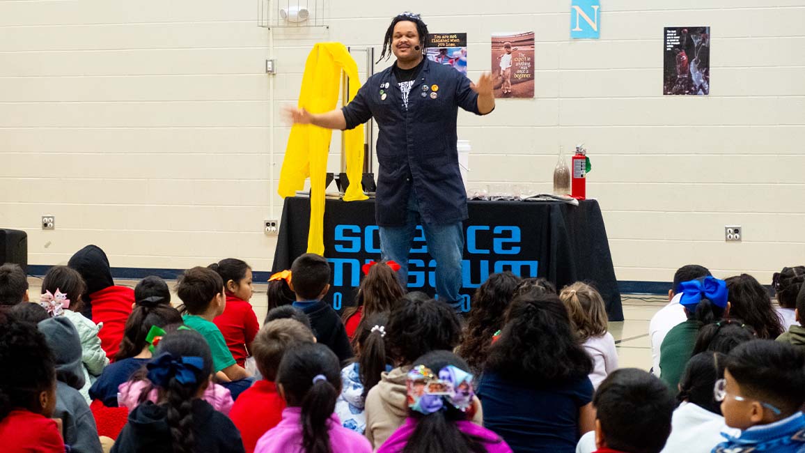A Science Museum Oklahoma educator leads an engaging live science demonstration for elementary students during a STEAM outreach program.