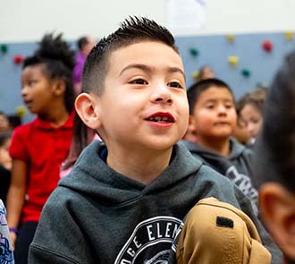 Young student smiling during an interactive STEAM Live science assembly presented by Science Museum Oklahoma.