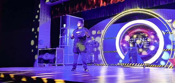 A Science Museum Oklahoma educator performs on stage during Science Live, a high-energy show with live experiments and STEM demonstrations.