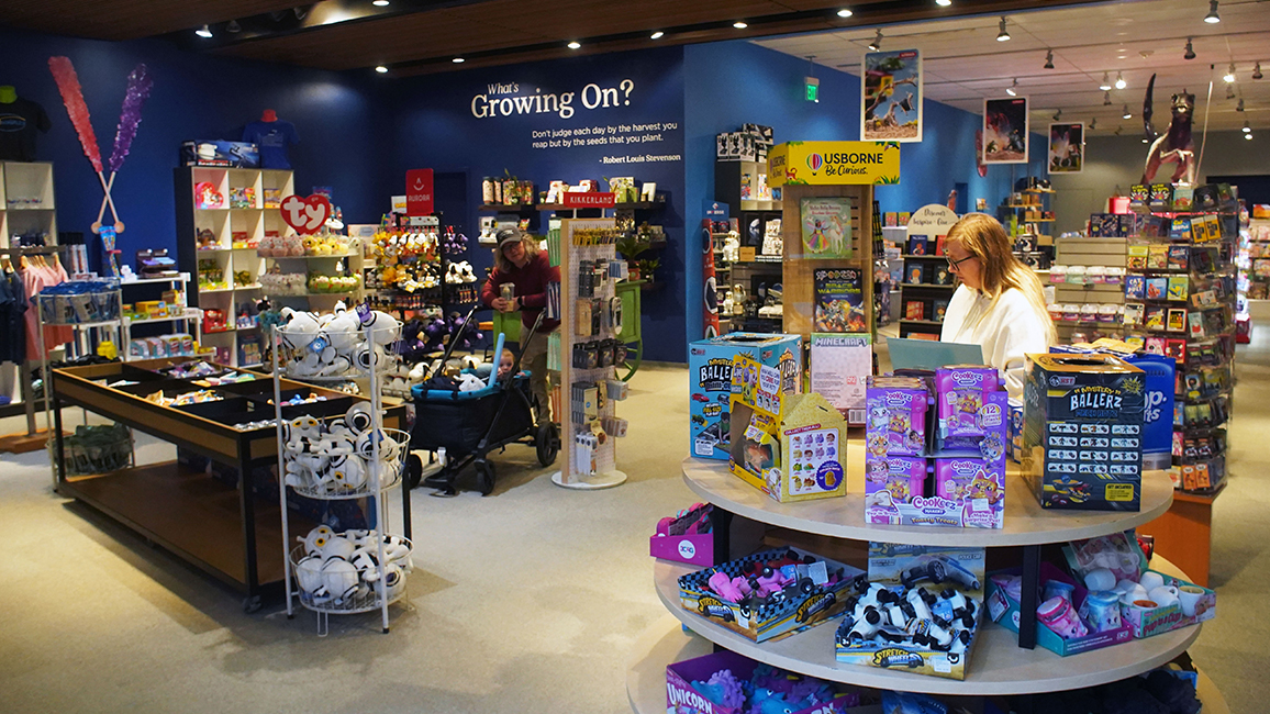 The Science Shop features shelves of science kits, plush toys, and educational games perfect for curious kids and thoughtful gifts.