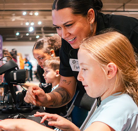 A Science Museum Oklahoma volunteer shows a child how to use a microscope at the annual Women in STEAM Conference.