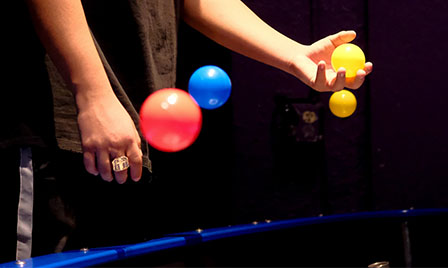 A visitor at Science Museum Oklahoma demonstrates air pressure and gravity with floating balls in a hands-on physics exhibit.